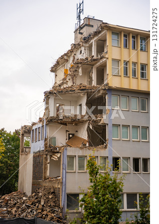 Partially demolished office building with exposed floors, walls and debris. Urban decay and architectural transformation in progress. Partially demolished office building with exposed floors, walls and debris. Urban decay and architectural transformation in progress. 131724275