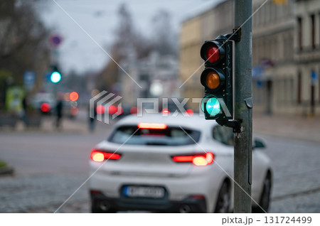 traffic light on the street junction with beautiful bokeh, city with cars in the background 131724499