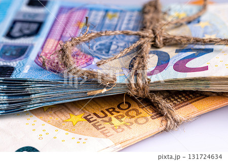stack of euro banknotes tied with burlap string, close-up, wealth and prosperity concept 131724634