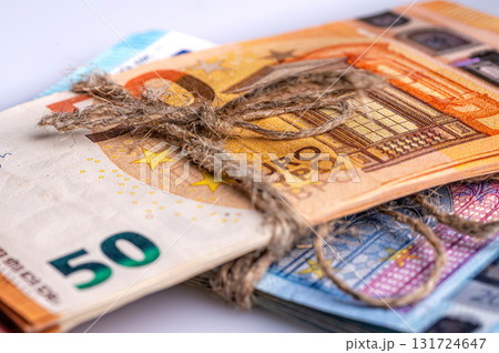 stack of euro banknotes tied with burlap string, close-up, wealth and prosperity concept 131724647