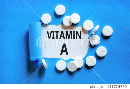 Vitamin A symbol. Concept words Vitamin A on beautiful white paper. White pills tablets. Beautiful blue background. Medical healthy lifestyle Vitamin A concept. Vitamin A symbol. Concept words Vitamin A on beautiful white paper. White pills tablets. Beautiful blue background. Medical healthy lifestyle Vitamin A concept. 131724750