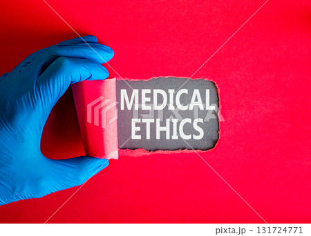 Medical ethics symbol. Concept words Medical ethics on beautiful grey paper. Doctor hand in blue medical glove. Beautiful red background. Healthy lifestyle medical ethics concept. Medical ethics symbol. Concept words Medical ethics on beautiful grey paper. Doctor hand in blue medical glove. Beautiful red background. Healthy lifestyle medical ethics concept. 131724771
