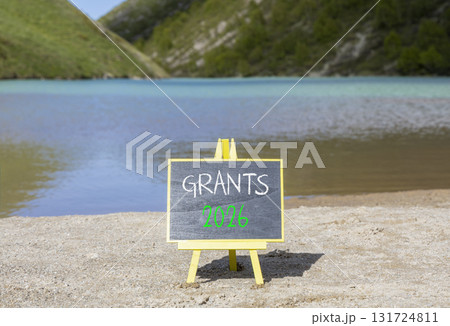 Grants 2026 symbol. Concept words Grants 2026 on beautiful black blackboard. Beautiful mountain lake sand beach background. Business and grants 2026 concept. Copy space. Grants 2026 symbol. Concept words Grants 2026 on beautiful black blackboard. Beautiful mountain lake sand beach background. Business and grants 2026 concept. Copy space. 131724811