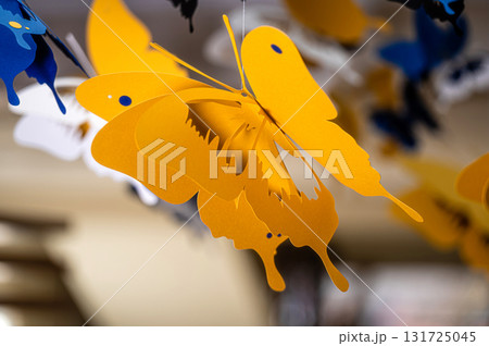 ceiling decorated with decorative colored paper butterflies, selective focus, blurred background 131725045
