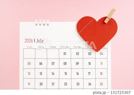 July 2026 desk calendar with red heart note on pink color background. 131725307