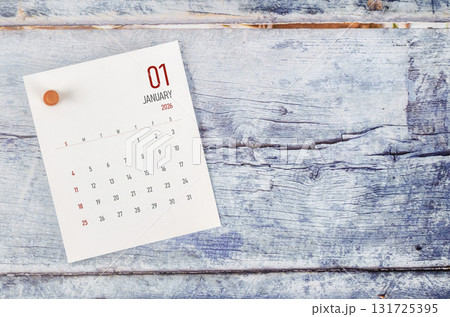 January 2026 monthly calendar and wooden push pin on blue wooden background. 131725395