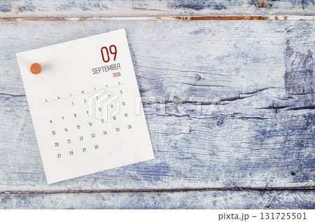 September 2026 monthly calendar and wooden push pin on blue wooden background. September 2026 monthly calendar and wooden push pin on blue wooden background. 131725501