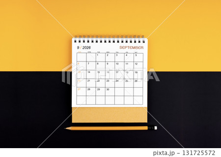 Top view of September 2026 desk calendar and pencil on yellow and black color. 131725572