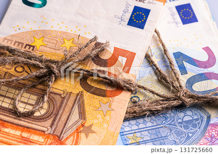 stack of euro banknotes tied with burlap string, close-up, wealth and prosperity concept 131725660