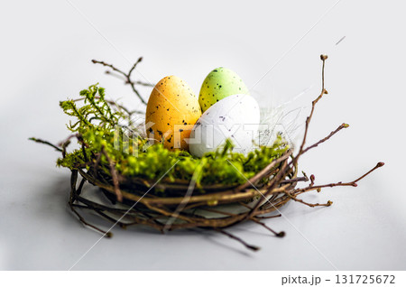 nest with colored Easter eggs isolated on a light defocused background, easter decorations, close-up nest with colored Easter eggs isolated on a light defocused background, easter decorations, close-up 131725672