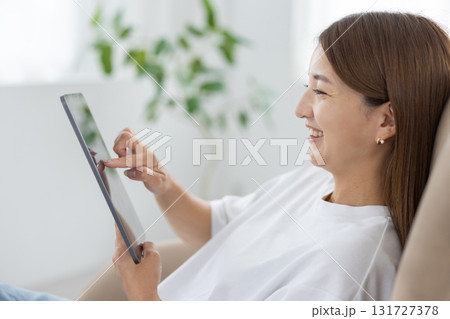 チェアに座ってタブレットを操作する若い女性 131727378