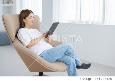 チェアに座ってタブレットを操作する若い女性 131727380