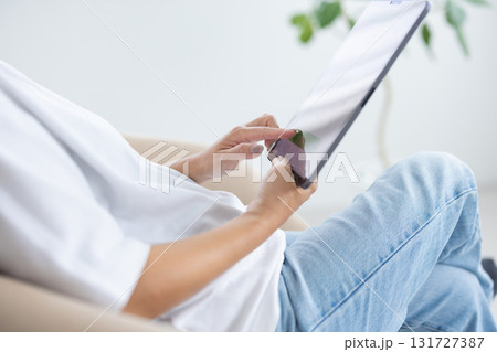 チェアに座ってタブレットを操作する若い女性 131727387