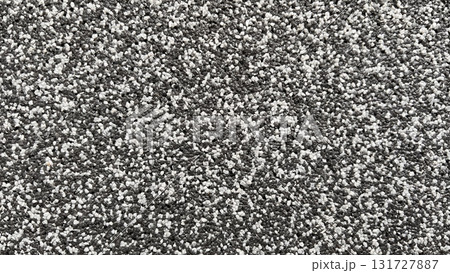 Texture of gray and white gravel covers the ground, creating a visually striking surface in bright light Texture of gray and white gravel covers the ground, creating a visually striking surface in bright light 131727887