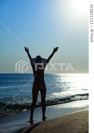 Woman in bikini walking on the beach 131729010