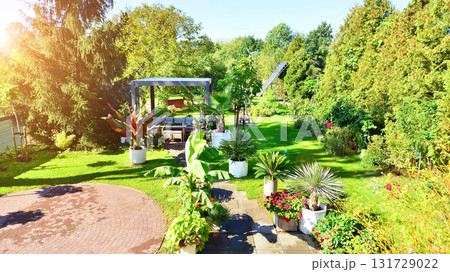 Beautiful summer garden with green grass, exotic plants and aluminum pergola. Professional luxury gardening concept. 131729022