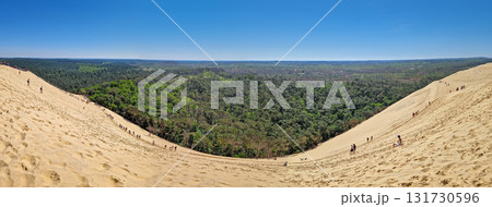 La Teste-de-Buch, Arcachon Bay, France - May 09, 2024: panoramic view of the immense Dune of Pilat, the tallest sand dune in Europe. Massive golden sandbanks dotted with multiple tourists 131730596