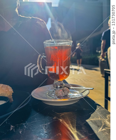 Hot Tea in Glass Cup with Steam in Sunlight Hot Tea in Glass Cup with Steam in Sunlight 131730705