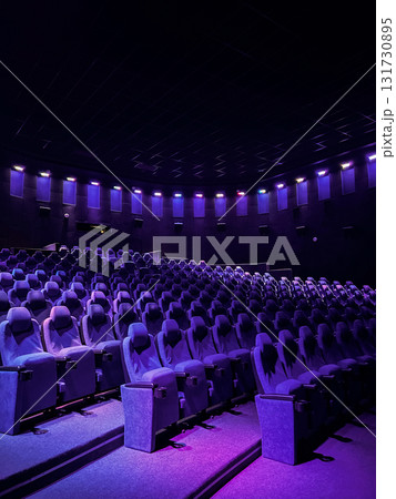 Vertical image of Cinema auditorium with empty purple chairs. Comfortable seats in movie theatre. Cinema interior. 131730895