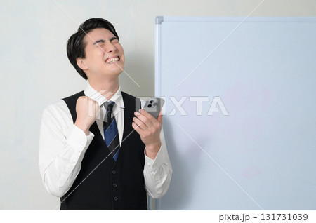 スマホを見て喜ぶ男性 131731039