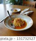 A bowl of pasta with a fork and a spoon on a wooden table 131732527