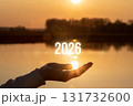 Future hope held in hand over sunset water view. 131732600