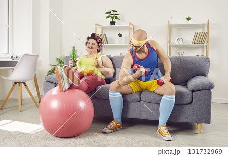 Funny spouses in sportswear sitting on sofa at home Funny spouses in sportswear sitting on sofa at home 131732969