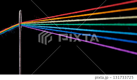 multi-colored threads for sewing in the form of a rainbow pass through an antique needle on a black background multi-colored threads for sewing in the form of a rainbow pass through an antique needle on a black background 131733725