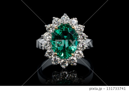 silver or gold ring with emerald stone and diamonds on black background silver or gold ring with emerald stone and diamonds on black background 131733741