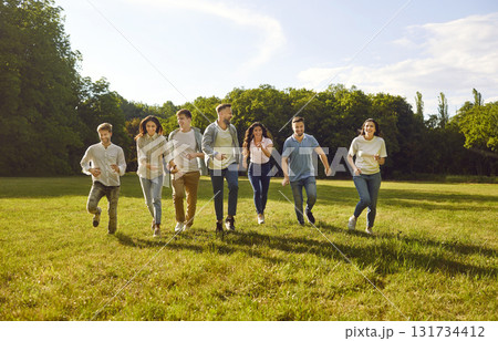 Group of happy, cheerful friends having fun and running together in the park in summer Group of happy, cheerful friends having fun and running together in the park in summer 131734412
