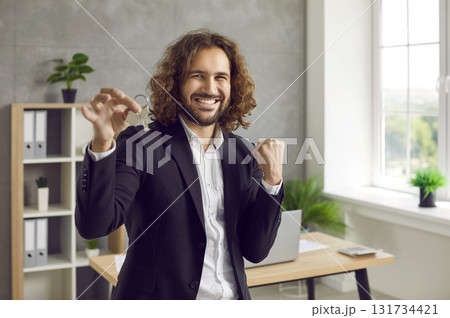 Portrait of a young happy smiling attractive man with keys in his hands. 131734421
