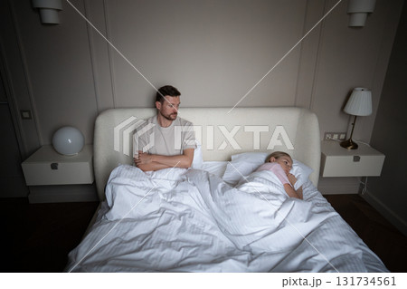 Angry couple in conflict, woman turned away from man in bed after argument. Failed intimacy attempt Angry couple in conflict, woman turned away from man in bed after argument. Failed intimacy attempt 131734561