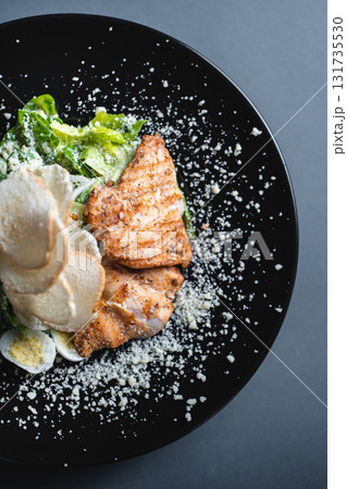 top view of caesar salad with chicken, romaine and egg on black background 131735530