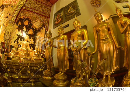Group of standing Buddha front of golden sitting statue of Phra Kaew Klao Chao Bun Rueang Buddha is enshrined in a church at Wat Den Sali Si Mueang Kaen temple or Wat Ban Den. Chiang Mai , Thailand. 131735764