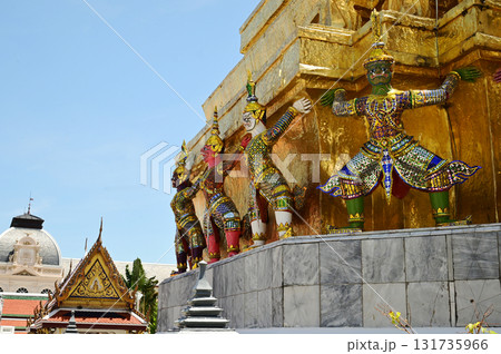 The large giant guardian standing guard carrying the pagoda base at Wat Phra Kaew Temple of the Emerald Buddha is a famous tourist attraction. Bangkok capital city in Thailand. The large giant guardian standing guard carrying the pagoda base at Wat Phra Kaew Temple of the Emerald Buddha is a famous tourist attraction. Bangkok capital city in Thailand. 131735966