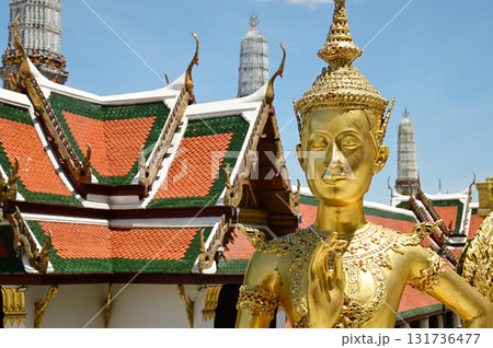 The face of golden Kinnari statue at Wat Phra Kaew. Kinnari are half-bird, half-woman creatures from Buddhist mythology. Wat Phra Kaew is a famous tourist attraction. The face of golden Kinnari statue at Wat Phra Kaew. Kinnari are half-bird, half-woman creatures from Buddhist mythology. Wat Phra Kaew is a famous tourist attraction. 131736477