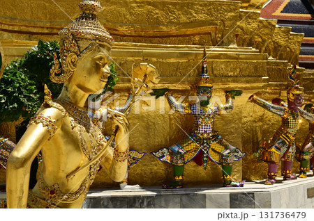 The face of golden Kinnari statue at Wat Phra Kaew. Kinnari are half-bird, half-woman creatures from Buddhist mythology. Wat Phra Kaew is a famous tourist attraction. 131736479