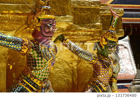 The large giant guardian standing guard carrying the pagoda base at Wat Phra Kaew Temple of the Emerald Buddha is a famous tourist attraction. Bangkok Thailand. The large giant guardian standing guard carrying the pagoda base at Wat Phra Kaew Temple of the Emerald Buddha is a famous tourist attraction. Bangkok Thailand. 131736480