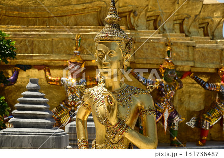 The face of golden Kinnari statue at Wat Phra Kaew. Kinnari are half-bird, half-woman creatures from Buddhist mythology. Wat Phra Kaew is a famous tourist attraction in Bangkok capital city, Thailand. The face of golden Kinnari statue at Wat Phra Kaew. Kinnari are half-bird, half-woman creatures from Buddhist mythology. Wat Phra Kaew is a famous tourist attraction in Bangkok capital city, Thailand. 131736487