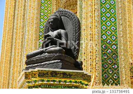 Outdoor black sitting Buddha on pole front of pavillion in Wat Phra Kaew or Temple of the Emerald Buddha is regarded as the most sacred Buddhist temple. Outdoor black sitting Buddha on pole front of pavillion in Wat Phra Kaew or Temple of the Emerald Buddha is regarded as the most sacred Buddhist temple. 131736491