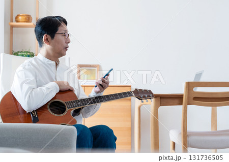 リビングでスマホを見る中年男性 リビングでスマホを見る中年男性 131736505