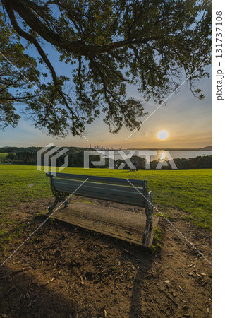 ニュージーランド　オークランドのバスション・ポイントから眺めるスカイタワーと港の風景と夕焼け空 131737108