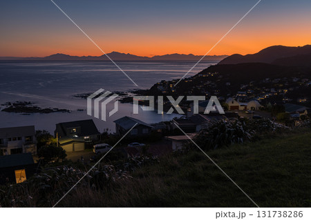 ニュージーランド　ウェリントンのアイランド・ベイから見えるクック海峡と南島の山々と夕焼け空 131738286