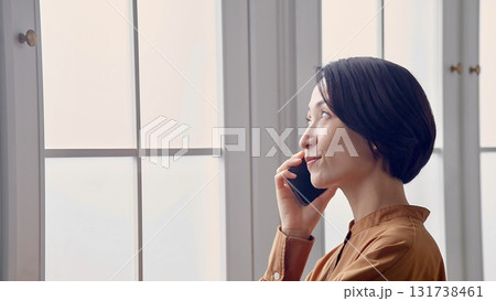 窓辺で電話をしている女性 131738461