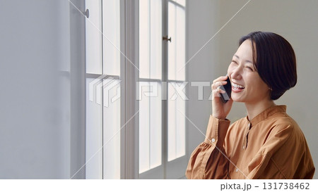 窓辺で電話をしている女性 131738462