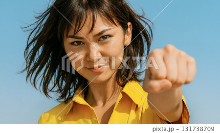 強い決意を持った表情で拳を突き出す女性 強い決意を持った表情で拳を突き出す女性 131738709