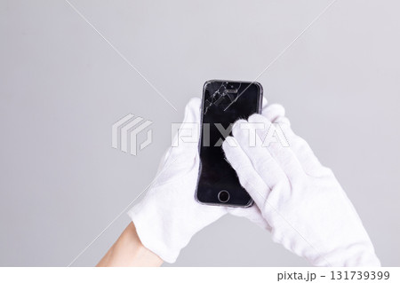 壊れたスマートフォンを持つ手元 壊れたスマートフォンを持つ手元 131739399