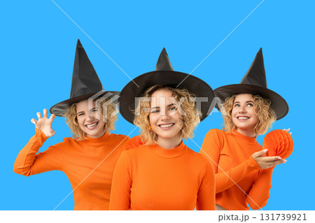 Three witches in black hats celebrate Halloween 131739921