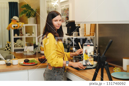 Young woman is broadcasting live from workshop how to prepare a vegetarian food Young woman is broadcasting live from workshop how to prepare a vegetarian food 131740092