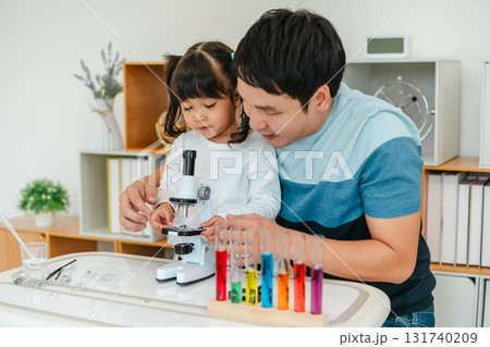 father and toddler girl scientist placing microscope slides with specimen. learning science 131740209